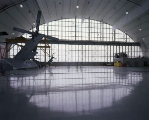 Inside a hangar. Showing the tail of a helicopter.